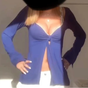Blå Design by si topp - Snygg blå långärmad topp med knyt framtill och djup v-ringning. Perfekt för en stilren look. Använd fåtal gånger och i perfekt skick. Priset kan diskuteras vid smidig handel. 