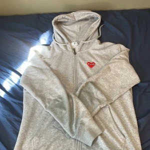 Grå Cdg zip hoodie - Säljer en grå hoodie från Comme des Garçons. Har använt den i ca ett halvår och passformen är fortfarande perfekt även om den har blivit lite för liten för just mig. Hör av vid funderingar🤗