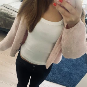 Rosa kofta - Mysig rosa kofta med knappar framtill. Perfekt för en avslappnad stil och kan enkelt matchas med olika toppar. Koftan har en mjuk och bekväm känsla.