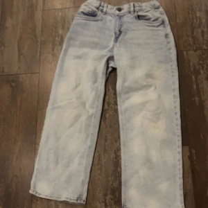 Ljusblå loose fit jeans - Säljer ett par ljusblå jeansbyxor med en avslappnad passform. Byxorna har en klassisk femficksdesign och knappgylf. Perfekta för en casual look.