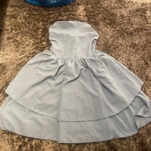 Ljusblå klänning - Jättefin ljusblå klänning med en smockad överdel och volangdetaljer. 