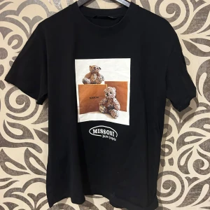 Svart t-shirt från palm angels - Snygg svart t-shirt från palm angels med ett unikt tryck av två nallebjörnar och en bok. Perfekt för dig som vill ha något stilrent men ändå med en twist. Passar bra till både jeans och shorts. Skriv för fler bilder, org pris 2400kr