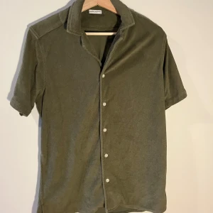 Olivgrön frottéskjorta från John Henric - Säljer en olivgrön kortärmad skjorta från John Henric i mjukt frottétyg. Skjortan har en klassisk krage och knappar framtill. Perfekt för en avslappnad stil. Perfekt nu till sommaren och passar bra till linnebyxor men även shorts. Använd endast ett fåtal gånger. Skick 9/10. Nypris: 599. Mitt pris: 299. (Slutsåld) Vid intresse skicka gärna ett meddelande!