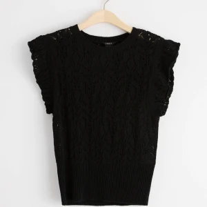 Svart spetsblus från Lindex - Säljer en elegant svart spetsblus från Lindex. Blusen har korta ärmar med volangdetaljer och en ribbad nederkant. Perfekt för att ge en stilren touch till din outfit. Priset kan diskuteras.