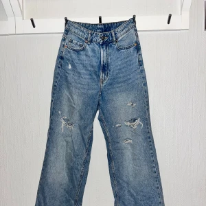 Blå jeans med slitningar från H&M - Säljer ett par blå jeans med slitningar, eftersom dom är förstora för mig. Använt två gånger. 