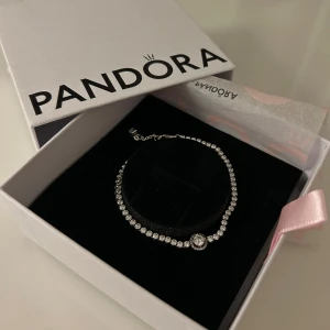 Pandora Tennisarmband - Tennisarmband med glittrande Halo från Pandora. Köpt för 999kr. Väl omhändertagen. S925 ALE, storlek 16.