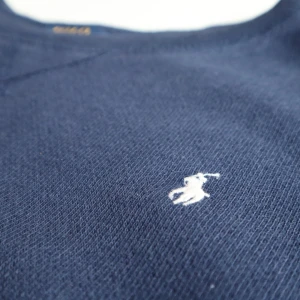  tröja från Polo Ralph Lauren - Snygg mörkblå tröja från Polo Ralph Lauren med det klassiska broderade logotypen på bröstet. Perfekt för en stilren look. Tröjan har en rund halsringning och är tillverkad i ett mjukt material. Original pris var 989 kr säljer för 678