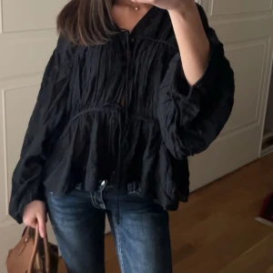 Svart blus i tunt material - En så snygg svart blus som knyts där fram. Blusen är i ett tunt material och är använd ca 3 gånger✨🌟💗
