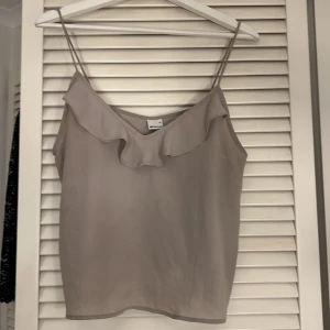 Beige linnetopp med volangdetalj - Beige linne från gina storlek M den har en liten fläck som man ser på andra bilden men det syns bara med blixt därav pris 