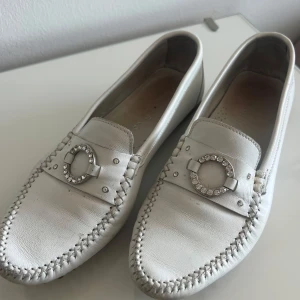 Vita loafers  - Snygga vita loafers i skinn med ett dekorativt spänne. Storlek 36.