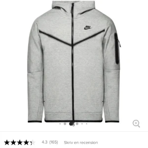 Grå hoodie från Nike med dragkedja - Nike Tech Fleece hoodie i ljusgrått med svarta detaljer och dragkedja hela vägen. Nypris är 1500 🥰Tröjan har huva, lång ärm och en praktisk ficka med dragkedja på ena ärmen. Perfekt för en sportig och avslappnad stil. Den är nästan oanvänd, men får ingen användning för den längre kan diskutera pris vid snabb affär🥰