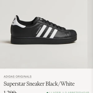 Adidas Superstar Sneaker Black/White - Klassiska Adidas Superstar sneakers i svart med vita ränder och detaljer. Skon har rund tå, platt sula och är tillverkad i syntetmaterial. Perfekt för dig som gillar en tidlös och sportig stil. Nypris: 1 300kr 💝