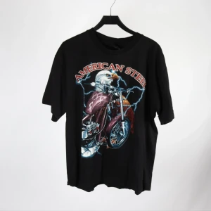 Vintage Y2K T-shirt  - Cool svart t-shirt med stort tryck av en motorcykel och örn på både fram- och baksidan. Texten 'American Steel' syns tydligt. Tillverkad i 100% bomull och har en klassisk passform med korta ärmar.
