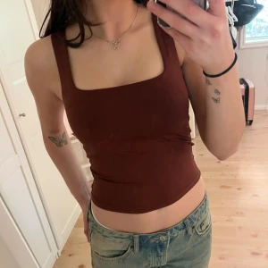Brun croppad linnetopp från mango - Säljer en brun croppad linnetopp från mando med breda axelband och fyrkantig ringning. Står storlek XS men passar även S