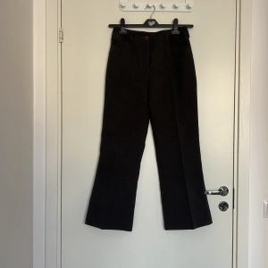 Grå kostymbyxor från KappAhl - Snygga grå kostymbyxor från KappAhl med klassisk passform och raka ben. Byxorna har hällor för bälte, knapp och dragkedja framtill. Perfekta för en stilren look.