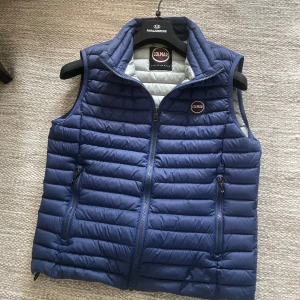 Blå dunväst från Colmar - Snygg blå dunväst från Colmar med snygg design och dragkedja framtill. Västen har två fickor med dragkedja . Perfekt för lager-på-lager och ger en stilren look. Storleken är 48 vilket motsvarar S …Orginal pris 2000 ish 