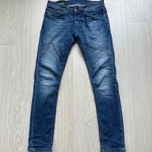 Blå dondup jeans  - Säljer ett par klassiska blå jeansbyxor från Dondup i modellen George. Byxorna har fem fickor, normal passform och stängs med dragkedja och knapp. Perfekta till vardags och har en snygg tvättad look. Nyaste modellen i W31