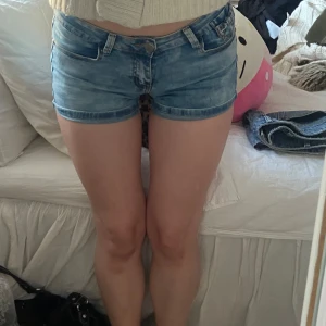 Lågmidjade jeans shorts - Lågmidjade jeansshorts med rosetter på bakfickorna🎀storlek 36 och stretchigt material💕 Inga defekter!