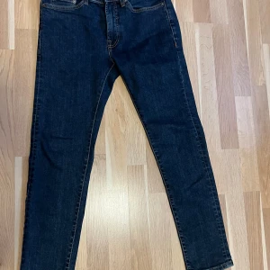 Mörkblå jeans från Dressmann - Säljer ett par klassiska mörkblå jeans från Dressmann. Byxorna har fem fickor, raka ben och normal passform. Perfekta för dig som gillar en tidlös stil och enkel design. Storlek 29-30.