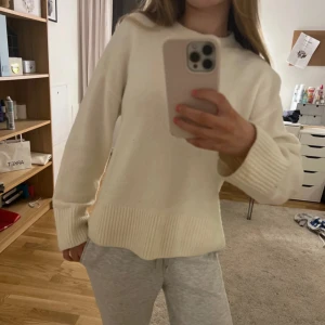 Vit stickad tröja från & Other Stories - Säljer en stilren vit stickad tröja. Tröjan har lång ärm, rund halsringning och breda ribbade muddar vid ärmslut och nederkant. Perfekt för lager-på-lager och enkel att matcha med allt. Lite nopprig skicket syns på bilderna