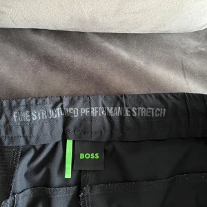 Hugo Boss byxor - Säljer ett par tränings/friluftsbyxor från märket Hugo Boss, från deras activewear linje. Passar slimfit med tapered leg. Storlek XL. Knappt använda.