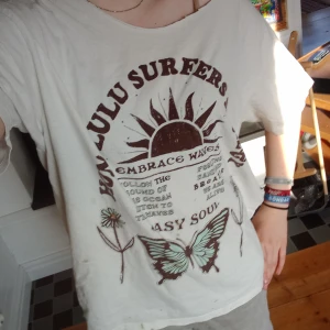 vit t-shirt med tryck - en vit t-shirt med tryck på en fjäril, en sol och lite text^^har en baggy fit