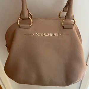 Beige handväska från Victoria's Secret -  Säljer min beiga handväska från Victoria’s Secret!! Skitsnygg och får plats med så så mycket, den är otroligt smidig att ha med sig överallt!💞💞