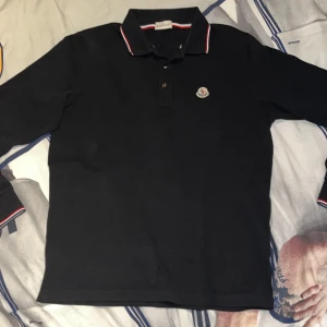 Moncler långärmad piké - Säljer denna helt galna Moncler pikén i storlek M, passar S också. Skick 9/10 nästan som en ny. En av dom fetaste plaggen just nu🔥