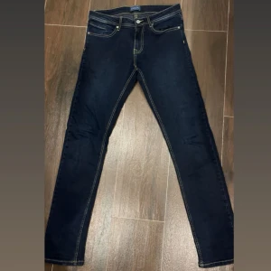 Mörkblå jeans från Emblems - Säljer ett par mörkblå jeans från Emblems ett spanskt märke med kontrastsömmar och klassisk femficksdesign. Jeansen har slim fit passform helt perfekts för grisch stilen. Säljer billigt eftersom har bytt stil