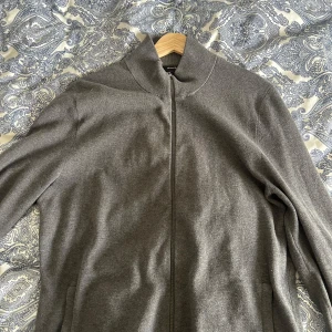 Grå ziptröja från Massimo Dutti - Snygg grå ziptröja från Massimo Dutti med hög krage och dragkedja framtill. Tröjan har en stilren och enkel design, perfekt för lager-på-lager och passar till många olika outfits. Ny pris 800kr. Pris går att diskuteras privat.