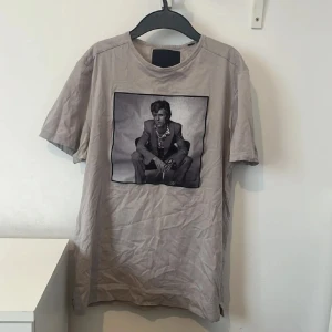 Beige t-shirt med fotoprint från Limitato - Säljer en beige t-shirt från Limitato med ett stort svartvitt fotoprint på bröstet, Perfekt för sommaren! inget tecken på användning!