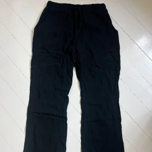 Svarta linnebyxor - Säljer ett par svarta byxor med rak passform. Byxorna har dragsko i midjan och är tillverkade i ett mjukt tyg som känns bekvämt. Perfekta för en avslappnad stil. Köpte på marknad i Spanien så har ingen lapp eller märke. Sitter jättebra på men har blivit lite för små för mig så säljer. Passar XS-S. Skriv för fler bilder💙