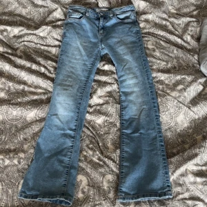 Ljusblå bootcut jeans - Säljer ett par ljusblå bootcut jeans från Cubus. Jeansen har klassisk femficksdesign, bälteshällor och är tillverkade i denim med lätt stretch. Perfekta för dig som gillar en retroinspirerad look med utsvängda ben. Modellen heter ”BAILEY BOOTCUT” storlek 152. 💗💗