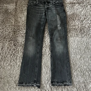 Nudie Jeans Bootcut Ola - Säljer ett par gråa jeans från Nudie I modellen Bootcut Ola. Jeansen har lite slitningar och en riktigt snygg fade men fortfarande i bra skick (se bilder). Storlek 30/32. Säljs då de inte passade mig. DM för frågor! 