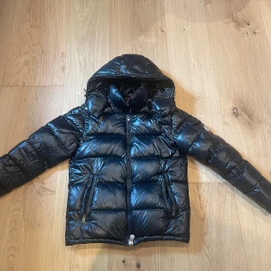 Svart moncler maya - Säljer en svart Moncler Maya i sådär skick. Den har lite skavmärken rygg o fram men de syns inte så mycket, däremot har den ett litet hål i ena armen som man ser på bilden. Kom gärna med bud eller om ni har frågor angående passform!