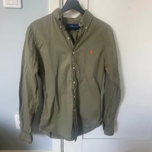 Olivgrön skjorta från Ralph Lauren - Säljer en olivgrön skjorta från Ralph lauren. Passar perfekt nu till sommaren. Knaps använd som ny.