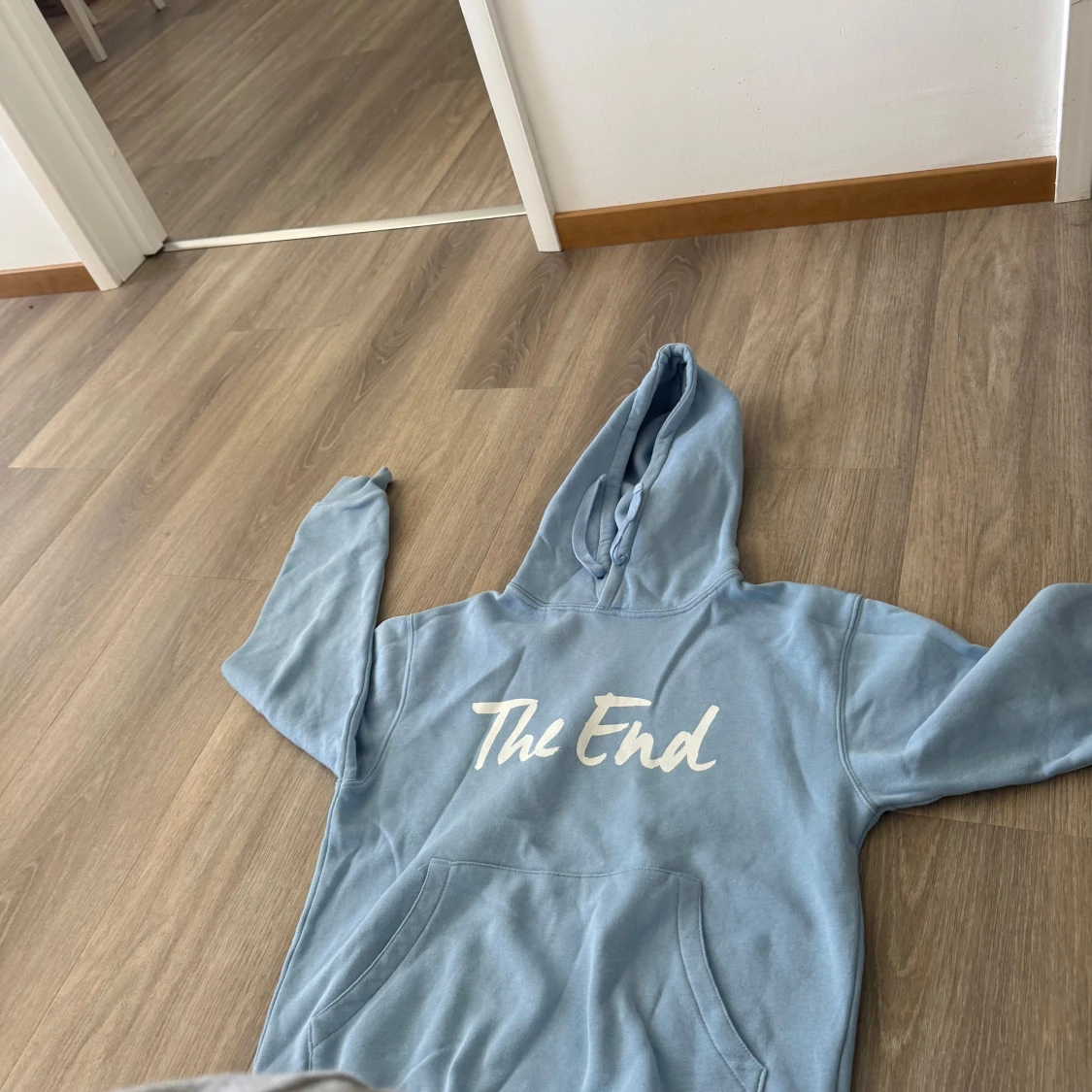 Ljusblå hoodie med texten 'The End'