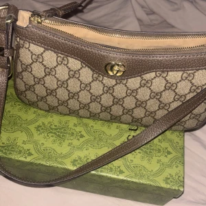 En handväska  - Handväska inte äkta😊 box och påse med kommer dragkedjan kan gå av då och då men den går att fixa igen det är bara att dra på den❤️