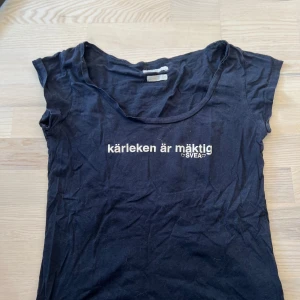 Marinblå t-shirt från Svea med tryck - Marinblå t-shirt från Svea med texten 'kärleken är mäktig' tryckt på bröstet. Klassisk rund halsringning och korta ärmar. Perfekt för en avslappnad stil.