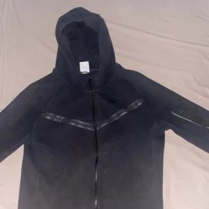 Svart Nike tech zipper  - Svart Nike tech zipper helt ny tvättad den har tappat lite färg på några ställen men ser ändå bra ut, den är size S fast passar ändå M ganska bra, pris kan diskuteras!