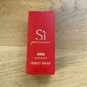 Sì Passione Intense Eau de Parfum från Giorgio Armani - Säljer en lyxig parfym, Sì Passione Intense Eau de Parfum från Giorgio Armani. Flaskan är röd med elegant svart kork och guldiga detaljer. Volymen är 50 ml. Doften är intensiv och feminin, perfekt för dig som gillar kraftfulla och passionerade parfymer.  Ca 75% av innehållet finns kvar. Ca 1 år gammal. 