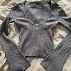 Grå backless tröja - Grå backless tröja med utsvängda ärmar, lite använd och har en liten skada på ena ärmen, ses bild 3. 