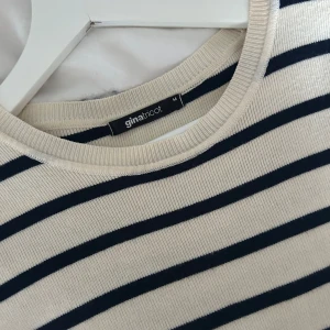 Randig kortärmad topp - Säljer en stilren randig topp i svart och vit med korta ärmar. Perfekt för en avslappnad look. Toppen är croppad och passar bra till jeans eller kjol. Från Gina tricot 