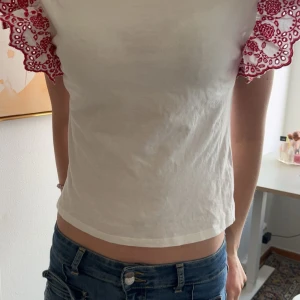 Vit topp med spetsärmar - Säljer en vit topp med korta ärmar i röd spets från Zara 