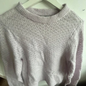 Ljuslila stickad tröja med mönster - Supermjuk ljuslila stickad tröja med diskret mönster och rund halsringning. Super gullig o passar till det mesta💕