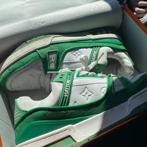 Louis Vuitton sneakers i grönt och vitt - Säljer ett par exklusiva Louis Vuitton sneakers i grönt och vitt med tydliga LV-detaljer och monogram på sidan. Skorna har snörning och en robust sula, perfekt för dig som vill sticka ut med lyxiga och trendiga sneakers. Tags, kvitto och certifikat brev medföljer. Skorna är använda en gång men 0 tecken på användning. Skorna är tvättade och rena innan de skickas.