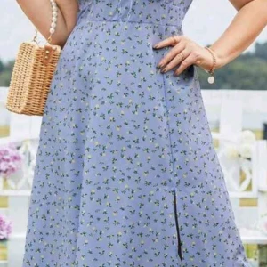 Ljusblå blommig klänning med slits - Superfin ljusblå klänning med små gröna blommor och en diskret slits framtill. Klänningen har en feminin passform och är perfekt för varma dagar. Bär den med en korgväska för en somrig look!               Passar storlek 1XL- 2XL