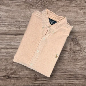 Ralph Lauren skjorta - 🔥 Ralph Lauren Skjorta – Rosa (S) 🔥  Säljer en snygg och klassisk rosa skjorta från Ralph Lauren i storlek S. Perfekt för både vardag och mer uppklädda tillfällen! ✨  ✔️ Färg: 💗 Rosa ✔️ Storlek: S ✔️ Märke: Ralph Lauren 🏇 ✔️ Mått: Längd 72 cm, armhåla till armhåla 54 cm, axel till axel 50 cm ✔️ Anledning till billigt pris finns på sista bilden 📸  📍 Finns för avhämtning i Linköping eller kan skickas 📦 mot fraktkostnad. 💬 Hör av dig vid intresse!