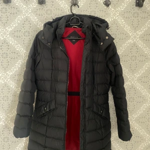 Svart dunjacka från Gant med  - Säljer en svart dunjacka från Gant i storlek XS. Jackan är i fint skick, tecken på användning kan förekomma men inga större defekter vid inspektion :)