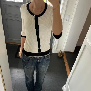 Vit stickad kofta  - Vit trekvartsärmad stickad kofta med svarta ränder från H&M i storlek S. Fint skick. Använd gärna köp nu!